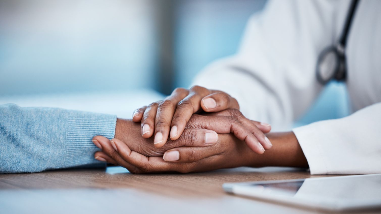 Healthcare professional holding patient's hand